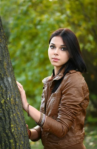 Mooie elegante brunette vrouw permanent in een park in het najaar van — Stockfoto