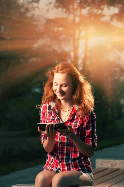 Redhead girl sitting in city park — Stock Photo, Image