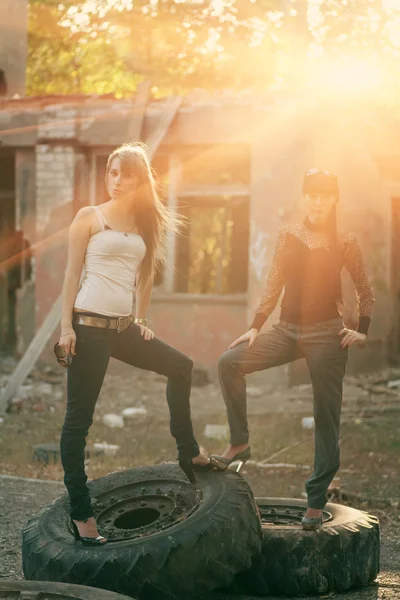 Two women standing on a tyres outdoors — Stock Photo, Image