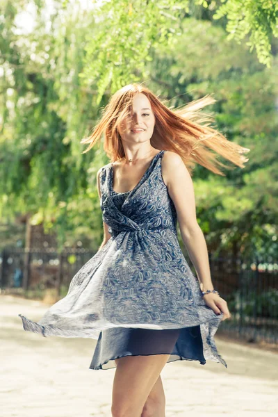 Young pretty woman dancing in city park — Stock Photo, Image