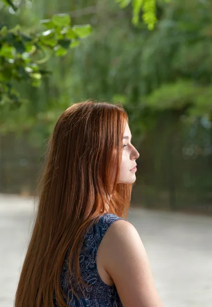 Zijaanzicht van een rode donkerharige vrouw buitenshuis — Stockfoto