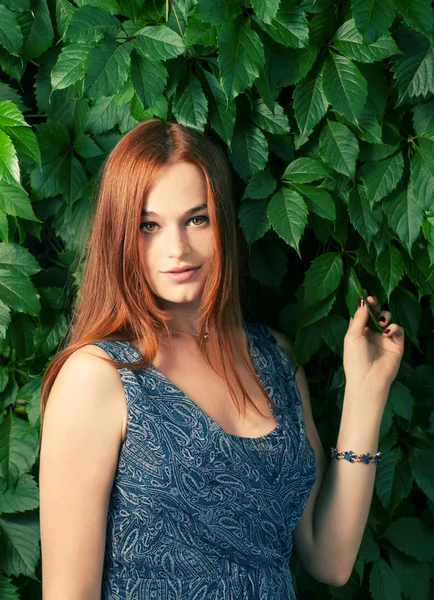 Femme aux cheveux rouges contre le mur de lierre — Photo