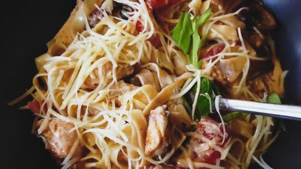 Girando espaguetis caseros en crema agria de un plato en una horquilla de acero — Vídeos de Stock