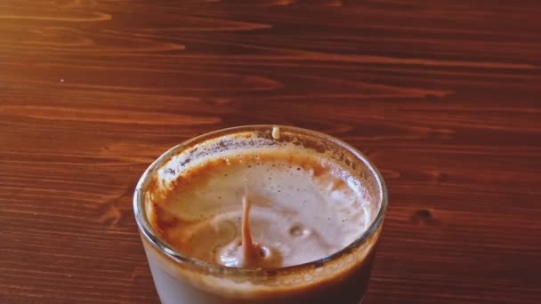 POV rozlewanie kawy w szklance w kroplach, powolny ruch spadających kropli kawy — Wideo stockowe