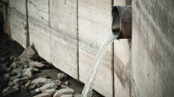 Verunreinigtes Wasser fließt aus der verwitterten Leitung in den Fluss, Umweltverschmutzungskonzept — Stockvideo