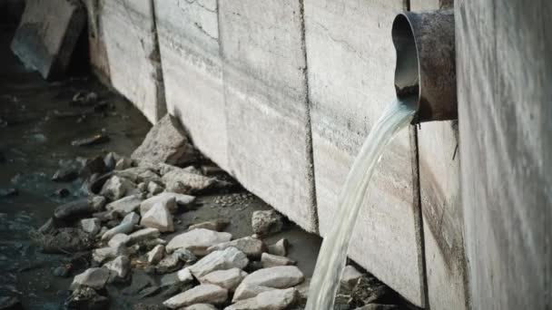 Vuil water dat uit de pijp stroomt in betonnen wand — Stockvideo