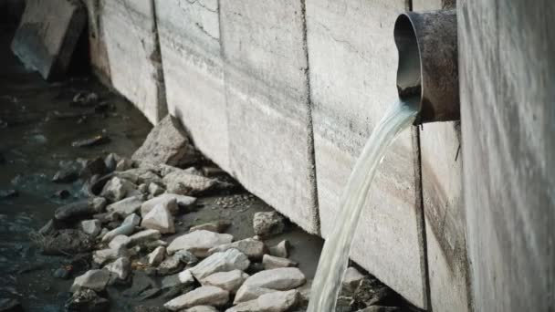 Agua sucia que fluye de la tubería en la pared de hormigón — Vídeos de Stock