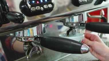 Barista kahve makinesinden taze kahve yapıyor. Espresso modern kahve dükkanındaki espresso makinesinden fincana dökülüyor.