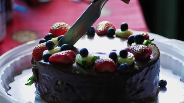Mujer corte pastel de crema con arándanos y fresas en el plato — Vídeos de Stock