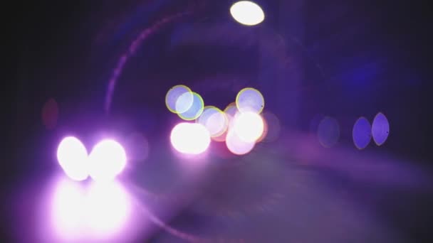 Feux de circulation urbains nocturnes fusées éclairantes circulaires de lentille vintage à monture C en violet. Trafic hors foyer avec des fusées éclairantes à monture C vintage. — Video