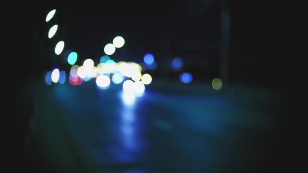 Defocused car lights in the night handheld in blue color blurred shot — Stock Video