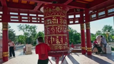 Yedi Gün Pagoda 'sında dua eden kadın Elista şehrinde, Kalmyk Republic, Rusya. Om mani padme hum mantra Sanskritçe, Tybetçe ve Moğol dillerinde yazılmıştır.