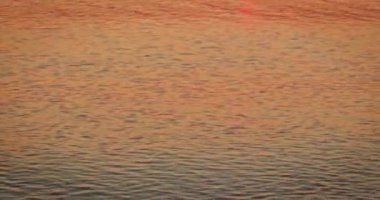 Su yüzeyinde günbatımı ışığı olan sakin bir deniz. Günbatımında okyanusta meditasyon manzarası. Huzurlu deniz manzarası.