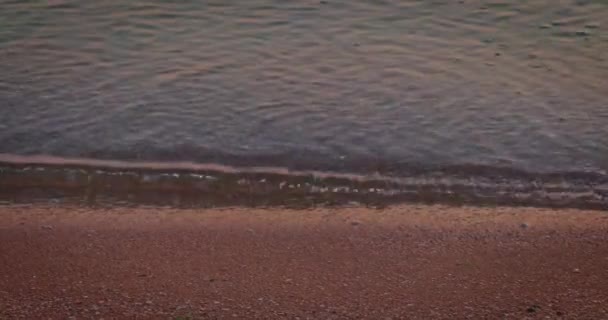 Agua de mar tranquila en la playa de arena con huellas. — Vídeo de stock