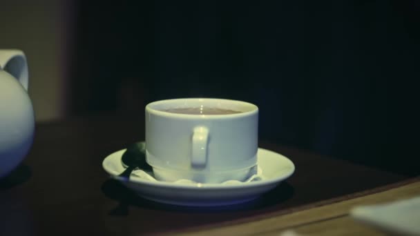 Frau holt Tasse Tee aus der Tischplatte in Cafeteria — Stockvideo