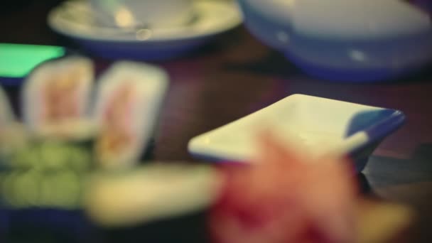 Wlewa sojowy souse do małej tradycyjnej japońskiej miski do jedzenia sushi — Wideo stockowe