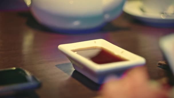 Close Shot of Eating nowoczesny typ Sushi Rolls w restauracji. Zanurzenie susi rolki do miski z soi souse — Wideo stockowe