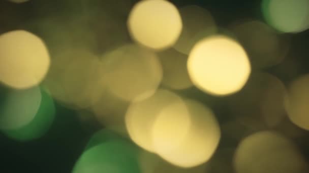 Χριστουγεννιάτικη γιρλάντα θολή με χρυσοκίτρινο και πράσινο φως αναβοσβήνει — Αρχείο Βίντεο