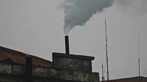 Ατμός και καπνός να βγαίνει από καπνοδόχο σε ξεπερασμένη οροφή κτιρίου του σταθμού παραγωγής ηλεκτρικής ενέργειας σε χειμερινό ουρανό — Αρχείο Βίντεο