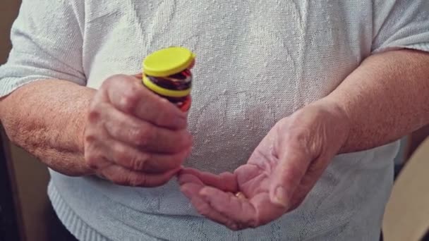 Mujer mayor derramando píldoras herbales fuera de la botella de la píldora en sus manos — Vídeo de stock