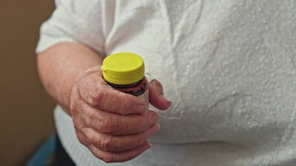 Senior γυναίκα προσπαθεί να ανοίξει το καπάκι μπουκάλι χάπι με τα δάχτυλα — Αρχείο Βίντεο