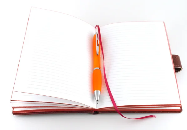 Notitieboek en oranje pen — Stockfoto