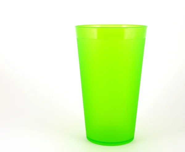 Зелена пластикова чашка над білим — стокове фото