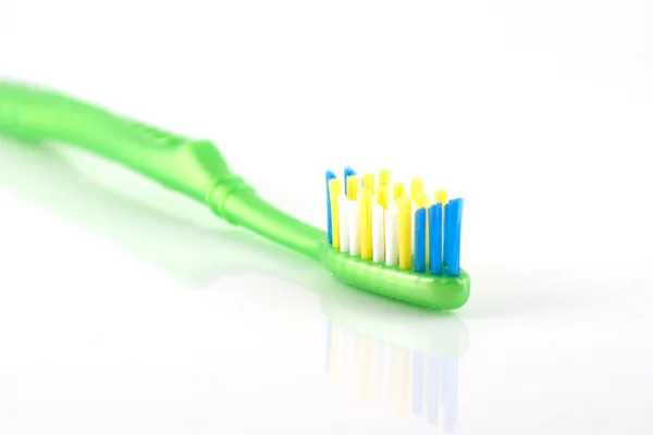Зубная щетка с зеленой ручкой — стоковое фото