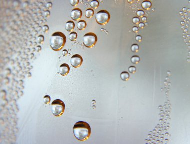 eğimli cam üstünde su damlaları