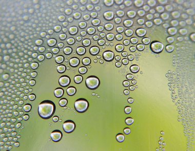 eğimli cam üstünde su damlaları