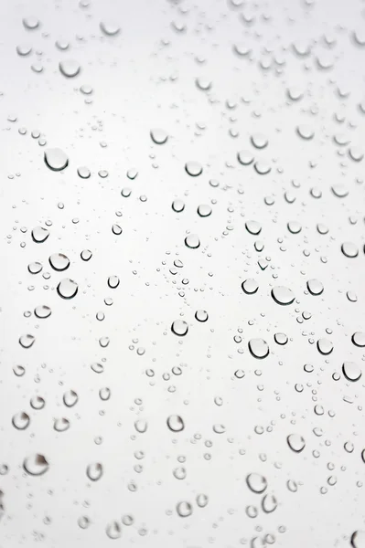 Капли дождя на наклонное окно — стоковое фото