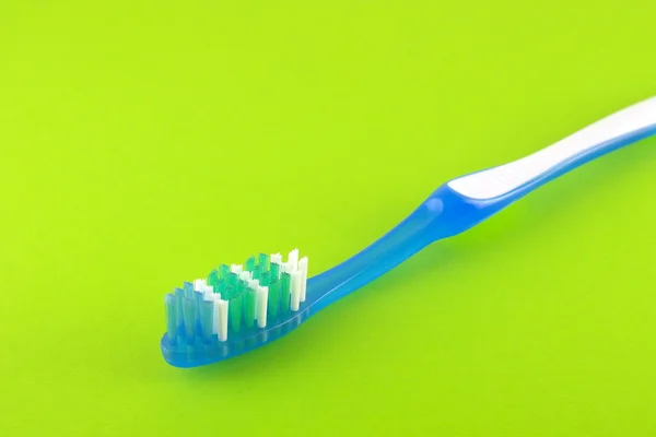 Tooth-brush over bright green — Stock Photo, Image