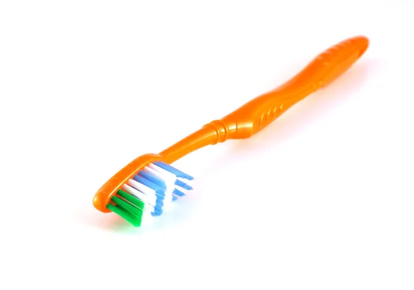 Cepillo de dientes naranja sobre blanco — Foto de Stock