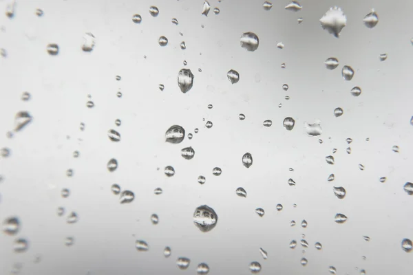 Cadute di pioggia sul finestrino. DOF poco profondo . — Foto Stock
