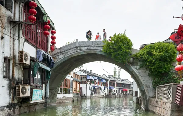 Os turistas caminham na ponte na aldeia na água — Fotografia de Stock