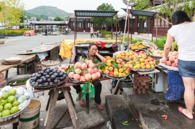 Çinli kadın meyve satıyor.