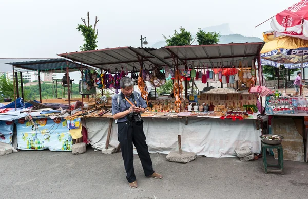 中国の観光市場の露店近くに立っています。 — ストック写真