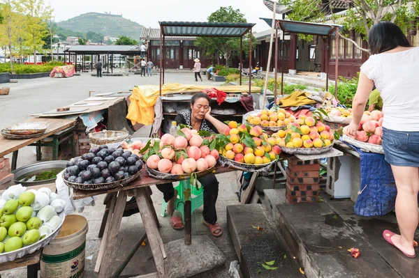 Çinli kadın meyve satıyor. — Stok fotoğraf
