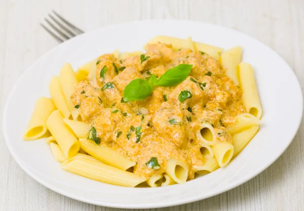 Penne pasta with chicken meat, cream sauce and basil — Stock Photo, Image