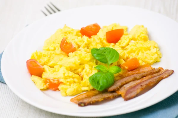 Scrambled eggs with tomatoes and bacon — Stock Photo, Image