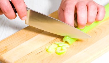 Şef kereviz bir ahşap tahta üzerinde kesme