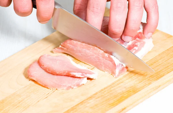 Chef snijdt het vlees op een houten plank — Stockfoto