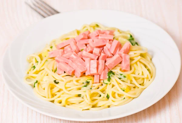 Спагетти с ветчиной, сыром и базиликом — стоковое фото