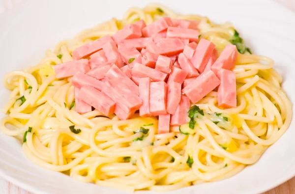 Спагетти с ветчиной, сыром и базиликом — стоковое фото