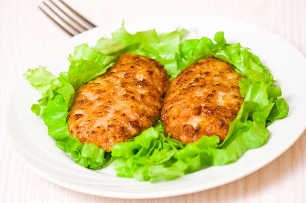 Hamburguesa con hojas de lechuga verde fresca en plato blanco — Foto de Stock