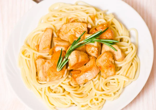 Skivad stekt kycklingfilé med vitlök och rosmarin. Garnera spaghetti — Stockfoto