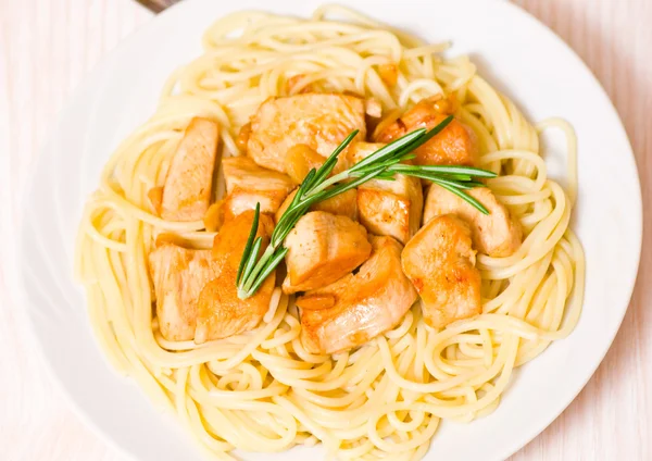 Sliced fried chicken fillet with garlic and rosemary. garnish spaghetti — Stock Photo, Image