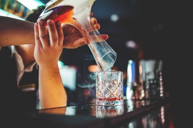 Barmen el barmeni dumanla kokteyl yapıyor.
