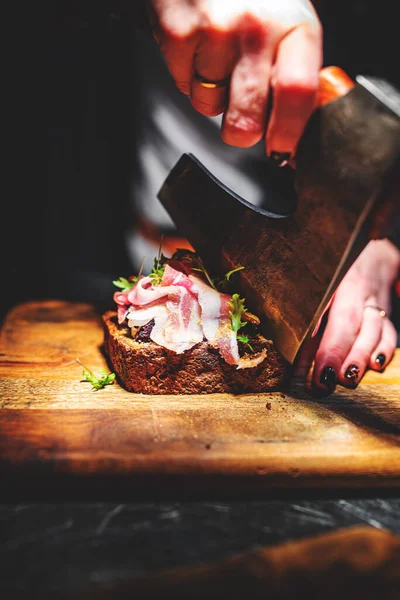 접시에 도끼를 맛있는 샌드위치를 자르는 요리사 — 스톡 사진