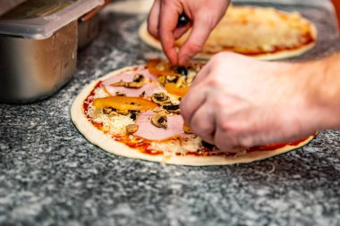 Şef fırıncının eli mutfakta pizza yapıyor. Pizza yapma süreci. İtalyan pizzası pişirmek